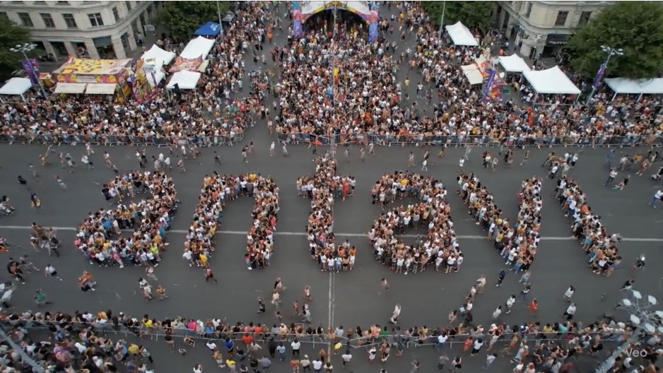Aerial-Aufnahme: Besuchende formen den Schriftzug «antavi» auf einem Stadtplatz
