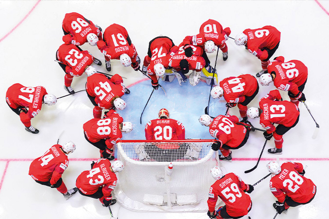 Spieler der Schweizer Eishockey-Nationalmannschaft im Kreis um das Tor vor dem Spiel